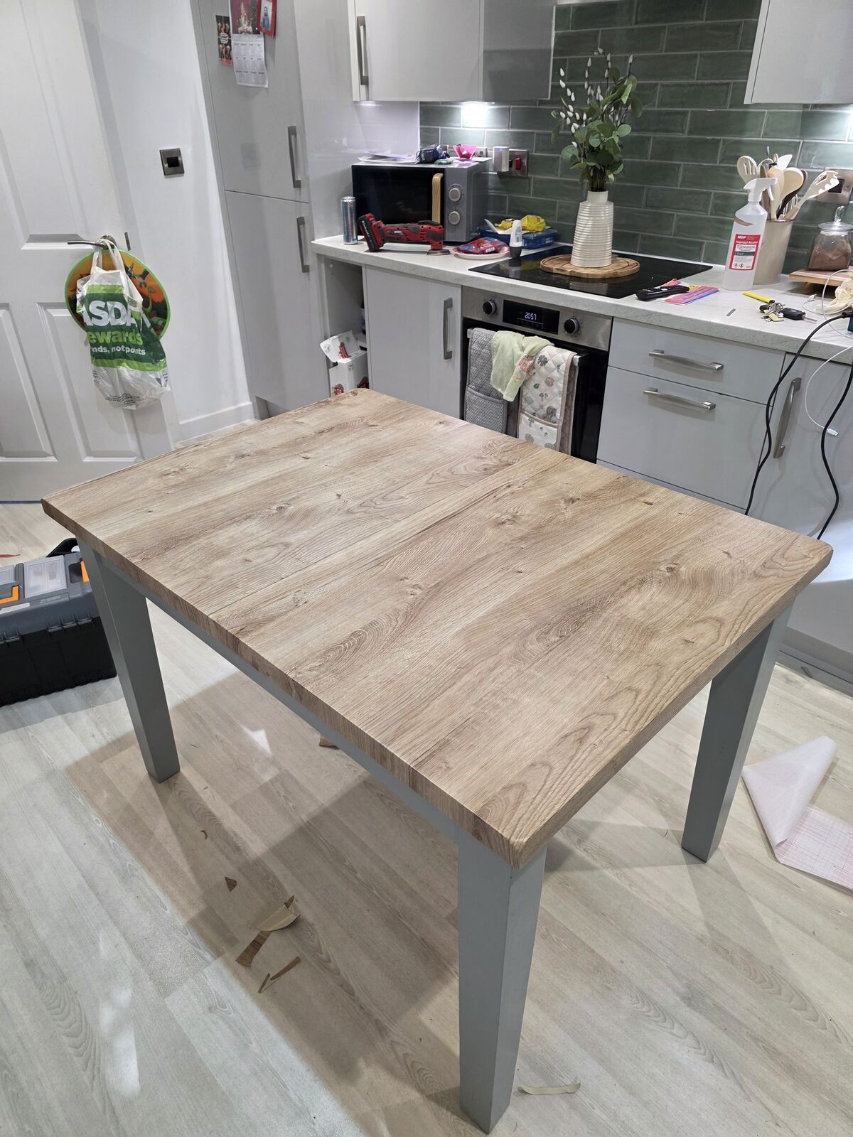 Dining table top after wrapping in a light wood-effect vinyl
